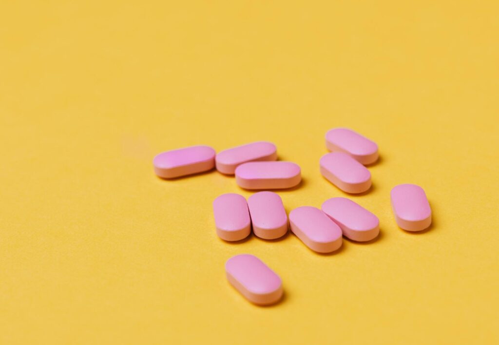 pink pills against a yellow background