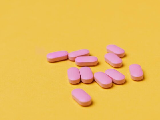 pink pills against a yellow background